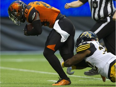 BC Lions #29 Steven Clarke is tackled by Hamilton Tiger-Cats  #32 C.J. Gable after Clarke picked up a loose ball.