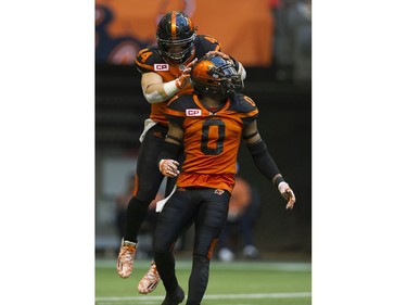 BC Lions #44  Adam Bighill jumps on teammate #0 Loucheiz Purifoy after Purifoy caused the Hamilton Tiger-Cats to lose possession of the ball.