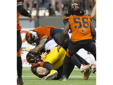 BC Lions #56 Solomon Elimimian watches as his teammates tackle  Hamilton Tiger-cats #2 Chad Owens.