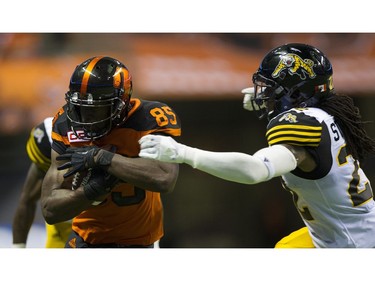 BC Lions #85 Shawn Gore is grabbed by Hamilton Tiger-Cats #22 Courtney Stephen.