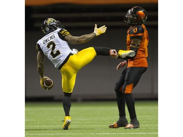 BC Lions #0 Loucheiz Purifoy holds onto Hamilton Tiger-Cats  #2 Chad Owens foot after Owens completed a pass.