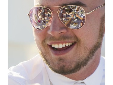 A toast is reflected in the sunglasses of Graeme Lockie at Le Diner en Blanc at Concord Pacific Place Vancouver, August 18 2016.