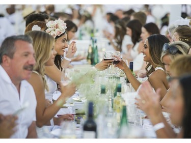 Simer Kaur ( L ) and Rubee Chane ( R ) toast at Le Diner en Blanc at Concord Pacific Place Vancouver, August 18 2016.