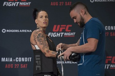 UFC fighter Bec Rawlings gets laced up by Adrian Rodriguez at the Hyatt Regency hotel in Vancouver on Thursday. Rawlings is on the main card of UFC on FOX 21 on Saturday at Rogers Arena, taking on Paige VanZant in a women’s strawweight bout.