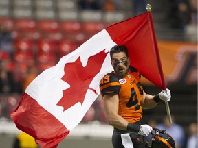 Jason Arakgi carries the Canadian flag onto the field before the B.C. Lions' game against the Toronto Argonauts in Vancouver on July 7. Gerry Kahrmann/PNG files