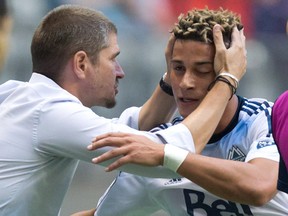 Vancouver Whitecaps' head coach Carl Robinson, left, congratulates Erik Hurtado on a goal.