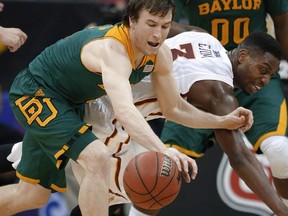 Baylor guard Brady Heslip, left, and Iowa State forward Melvin Ejim (3) chase a loose ball during the first half of an NCAA college basketball game in the final of the Big 12 Conference men&#039;s tournament in Kansas City, Mo., Saturday, March 15, 2014. The Toronto Raptors have signed free-agent guard Brady Heslip. THE CANADIAN PRESS/AP, Orlin Wagner