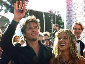 Actor Brad Pitt (L) waves to spectators as he arrives with his girlfriend actress Jennifer Aniston (R)  at the Shrine Auditorium in Los Angeles, CA, 12 September 1999.   (ELECTRONIC IMAGE) AFP PHOTO  Hector MATA/mn