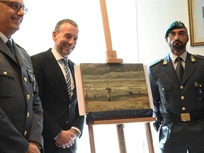 The director of Amsterdam&#039;s Van Gogh Museum Axel Ruger, second from left, stands next to the painting Seascape at Scheveningen by Vincent Van Gogh, during a press conference in Naples, Italy, Friday, Sept. 30 2016. This painting and another one, Congregation Leaving The Reformed Church of Nuenen, which had been stolen in an Amsterdam museum in 2002, were recovered by Naples investigators among the assets of a Camorra group. (Ciro Fusco/ANSA via AP)