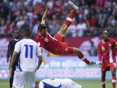 Canada's Adam Straith, top center, is sent flying after colliding with El Salvador's Roberto Dominguez during the first half of a CONCACAF World Cup soccer qualifying match Tuesday, Sept. 6, 2016, in Vancouver.