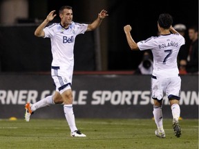Vancouver Whitecaps midfielder Andrew Jacobson, left, celebrates his goal against the Columbus Crew with midfielder Christian Bolanos during the second half of an MLS soccer match in Columbus, Ohio, Saturday. Vancouver won 3-1.