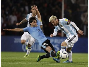 Uruguay's Nicolas Lodeiro slides in for a tackle on Argentina's Lionel Messi during a World Cup qualifying match Sept. 1. Seattle signed Lodeiro this summer and the playmaker has three goals and six assists in seven starts with the Sounders.