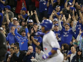 Toronto Blue Jays fans cheer as Edwin Encarnacion rounds the bases after he hit a two-run home run in the third inning of a baseball game against the Seattle Mariners, Monday, Sept. 19, 2016, in Seattle.