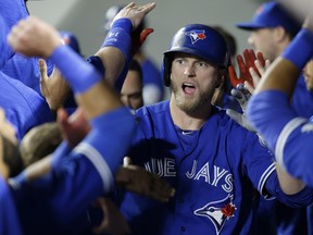 Toronto Blue Jays Michael Saunders of Victoria high-fives teammates in the dugout after scoring on a double by Josh Donaldson against the Orioles in Baltimore on April 21. Saunders' production has fallen off in the second half of the season, making the chances of a big contract with the Jays doubtful.