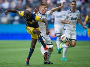 New York Red Bulls' Bradley Wright-Phillips, left, scores a goal as Vancouver Whitecaps' Tim Parker defends during second half MLS soccer action in Vancouver, Saturday, September 3, 2016.