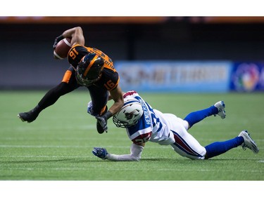 B.C. Lions' Bryan Burnham, left, is hit by Montreal Alouettes' Greg Henderson after making a reception during the first half of a CFL football game in Vancouver, B.C., on Friday September 9, 2016.