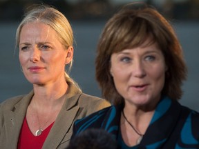 Catherine McKenna, left, Minister of Environment and Climate Change, listens as B.C. Premier Christy Clark speaks after the federal government announced approval of the Pacific NorthWest LNG project, at the Sea Island Coast Guard Base, in Richmond on Tuesday.