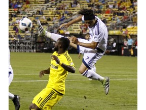 Whitecaps midfielder Christian Bolanos clears the ball against the Columbus Crew's Cedrick Mabwati last Saturday. Vancouver won 3-1 and now has a slim chance to make the MLS playoffs.