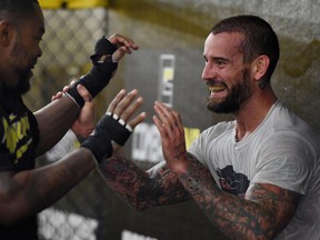 CM Punk, right, spars with Mike 'Biggie' Rhodes during a training session at Roufusport Martial Arts Academy on in Milwaukee, Wisc/., in August.