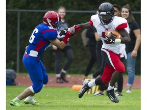 Abbotsford Panthers’ running back Samwel Uko finds a lane between Centennial Centaurs’ Arif Ansari (left) and Uriah Hestdalen on Friday in Coquitlam. (Gerry Kahrmann, PNG photo)