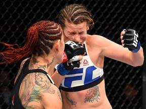 (L-R) Cristiane 'Cyborg' Justino of Brazil punches Leslie Smith in their women's catchweight bout during UFC 198.