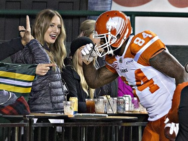 B.C. Lions Emmanuel Arceneaux (84) pretends to drink out of a fans cup after scoring a touchdown against the Edmonton Eskimos during first half CFL action in Edmonton, Alta., on Friday September 23, 2016.