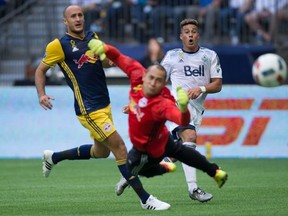 Vancouver Whitecaps' Erik Hurtado, right, watches as his shot sails wide of the net behind New York Red Bulls' goalkeeper Luis Robles as Aurelien Collin, left, looks on during first half MLS soccer action in Vancouver, Saturday, September 3, 2016.