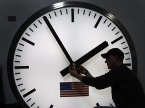 FILE - Dave LeMote uses an allen wrench to adjust hands on a stainless steel tower clock at Electric Time Company, Inc. in Medfield, Mass., in this March 7, 2014 file photo. Most Americans will set their clocks 60 minutes forward before heading to bed Saturday night March 7, 2015, but daylight saving time officially starts Sunday at 2 a.m. local time (0700GMT).