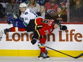 Vancouver Canucks' Guillaume Brisebois, left, is checked by Calgary Flames' Micheal Ferland during first period pre-season NHL hockey action in Calgary, Friday, Sept. 30, 2016.THE CANADIAN PRESS/Jeff McIntosh ORG XMIT: JMC101