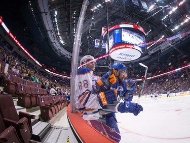 Vancouver Canucks' Emerson Etem, right, checks Edmonton Oilers' Brandon Davidson during the first period of a pre-season NHL hockey game at Rogers Arena last Wednesday.