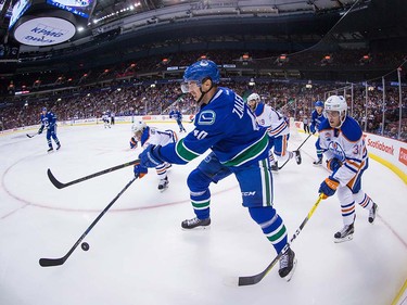 Vancouver Canucks' Mike Zalewski, centre, has his clearing pass stopped by Edmonton Oilers' Kris Versteeg, back left, as Drake Caggiula, right, watches during the first period of a pre-season NHL hockey game in Vancouver, B.C., on Wednesday September 28, 2016.