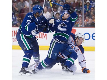 Vancouver Canucks' Alexander Edler, left, of Sweden, and Troy Stecher, centre, and Edmonton Oilers' Connor McDavid collide during the first period of a pre-season NHL hockey game in Vancouver, B.C., on Wednesday September 28, 2016.