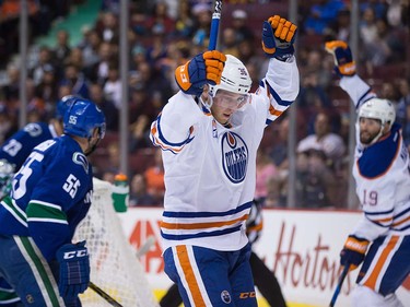 Edmonton Oilers' Drake Caggiula, centre, and Patrick Maroon, back right, celebrate Caggiula's goal against Vancouver Canucks' goalie Ryan Miller, back left, during the first period of a pre-season NHL hockey game in Vancouver, B.C., on Wednesday September 28, 2016.