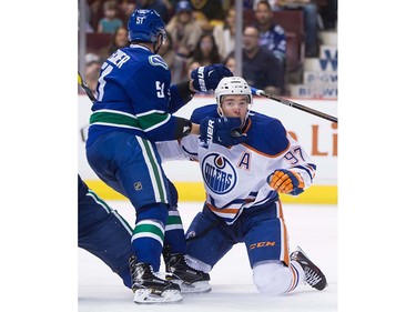 Vancouver Canucks' Troy Stecher, left, gets his glove in the face of Edmonton Oilers' Connor McDavid during the first period of a pre-season NHL hockey game in Vancouver, B.C., on Wednesday September 28, 2016.