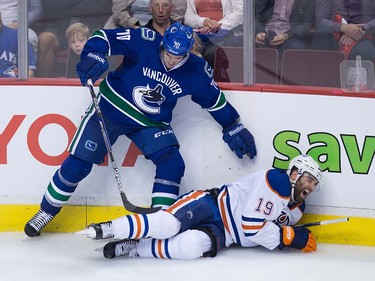 Edmonton Oilers' Patrick Maroon, right, reacts as he falls awkwardly on his left knee after being hit by Vancouver Canucks' James Sheppard during the third period of a pre-season NHL hockey game in Vancouver, B.C., on Wednesday September 28, 2016.