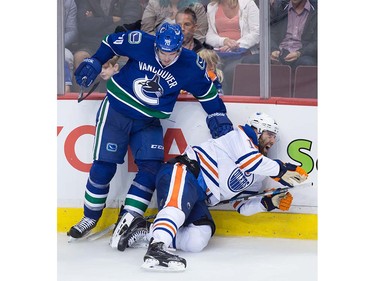 Edmonton Oilers' Patrick Maroon, right, reacts as he falls awkwardly on his left knee after being hit by Vancouver Canucks' James Sheppard during the third period of a pre-season NHL hockey game in Vancouver, B.C., on Wednesday September 28, 2016.