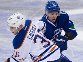 Troy Stecher, battling here against Drake Caggiula of the Oilers, is back in the Canucks' lineup tonight against Arizona.