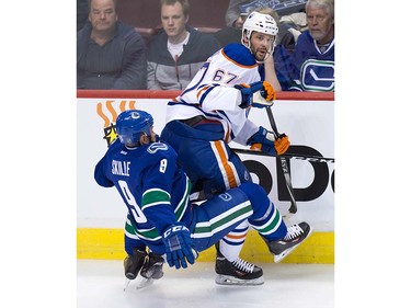 Edmonton Oilers' Benoit Pouliot, back, checks Vancouver Canucks' Jack Skille during the second period of a pre-season NHL hockey game in Vancouver, B.C., on Wednesday September 28, 2016.