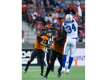 B.C. Lions' quarterback Jonathon Jennings, back left, passes as Montreal Alouettes' Kyries Hebert jumps and stretches to try and block it during the first half of a CFL football game in Vancouver, B.C., on Friday September 9, 2016.