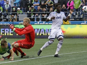 Seattle Sounders forward Jordan Morris, left, watches as his header goal heads to the net after he got it past Vancouver Whitecaps goalkeeper David Ousted, center, and defender Jordan Smith, right, in the second half of an MLS soccer match, Saturday, Sept. 17, 2016, in Seattle. The Sounders beat the Whitecaps 1-0.