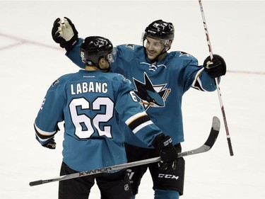San Jose Sharks' Kevin Labanc (62) celebrates with teammate Dylan DeMelo after Lablanc's game-winning goal in overtime against the Vancouver Canucks during an NHL preseason hockey game Tuesday, Sept. 27, 2016, in San Jose, Calif.  San Jose won 3-2.