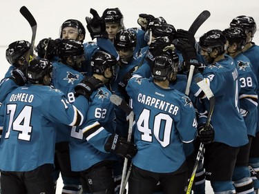 San Jose Sharks' Kevin Labanc (62) is mobbed by teammates after his game-winning goal in overtime against the Vancouver Canucks during an NHL preseason hockey game Tuesday, Sept. 27, 2016, in San Jose, Calif.  San Jose won 3-2.