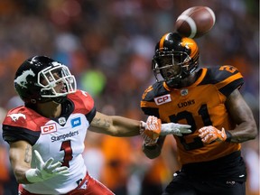 Calgary Stampeders Lemar Durant, left, watches the ball but fails to make the catch as B.C. Lions Ryan Phillips grabs his arm during the second half in Vancouver on Aug. 19.