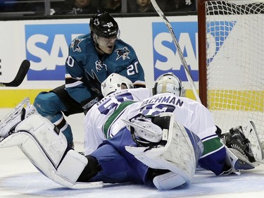 San Jose Sharks' Marcus Sorensen, top, has his shot blocked by Vancouver Canucks center Brendan Gaunce (50) and goalie Richard Bachman (32) during the first period of an NHL preseason hockey game Tuesday, Sept. 27, 2016, in San Jose, Calif.