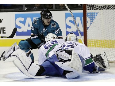 San Jose Sharks' Marcus Sorensen, top, has his shot blocked by Vancouver Canucks center Brendan Gaunce (50) and goalie Richard Bachman (32) during the first period of an NHL preseason hockey game Tuesday, Sept. 27, 2016, in San Jose, Calif.