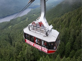 People stand on top of the Grouse Mountain cable car on opening day of the new Skyride Surf Adventure, in North Vancouver, B.C., on Friday, July 15, 2016. A special platform was built on top of the car to allow visitors to be outside while ascending the 1,610-metres up the mountainside on the largest tramway system in North America.