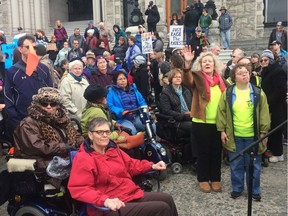 People take part in a protest in Victoria on Wednesday March 2, 2016. About 300 disabled people protesting on the steps of the British Columbia legislature cheered when an advocate called the government mean and shameful for introducing a fee for a bus pass that has been free.