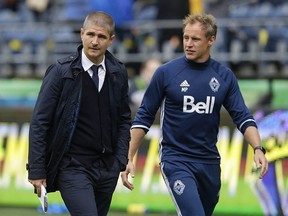 Vancouver Whitecaps head coach Carl Robinson, left, walks off the pitch with assistant coach Martyn Pert, right, after last Saturday's game against the Seattle Sounders.