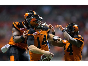 B.C. Lions' quarterback Travis Lulay, centre, celebrates his touchdown with Rolly Lumbala, left, and Jeremiah Johnson during the second half of a CFL football game against the Montreal Alouettes in Vancouver, B.C., on Friday September 9, 2016.