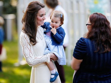Britain's Catherine, Duchess of Cambridge carries Princess Charlotte at a children's party at Government House in Victoria, Thursday, September 29, 2016.